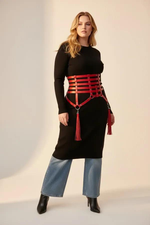 red faux leather caged waist harness with silver O-ring hardware and fringe tassels worn over grey dress