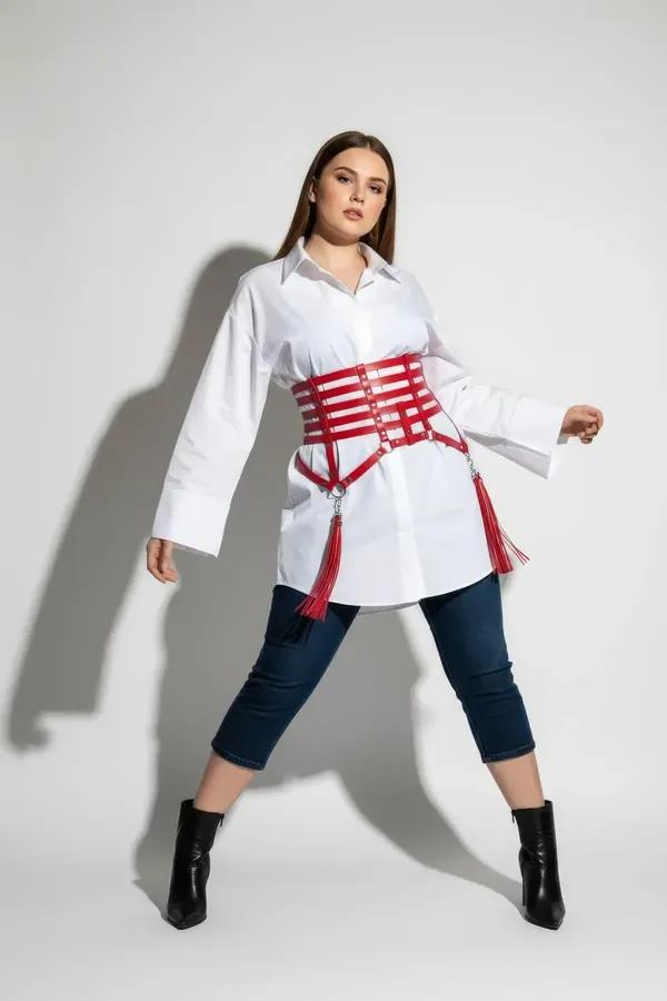 red faux leather caged waist harness with silver O-ring hardware and fringe tassels worn over grey dress