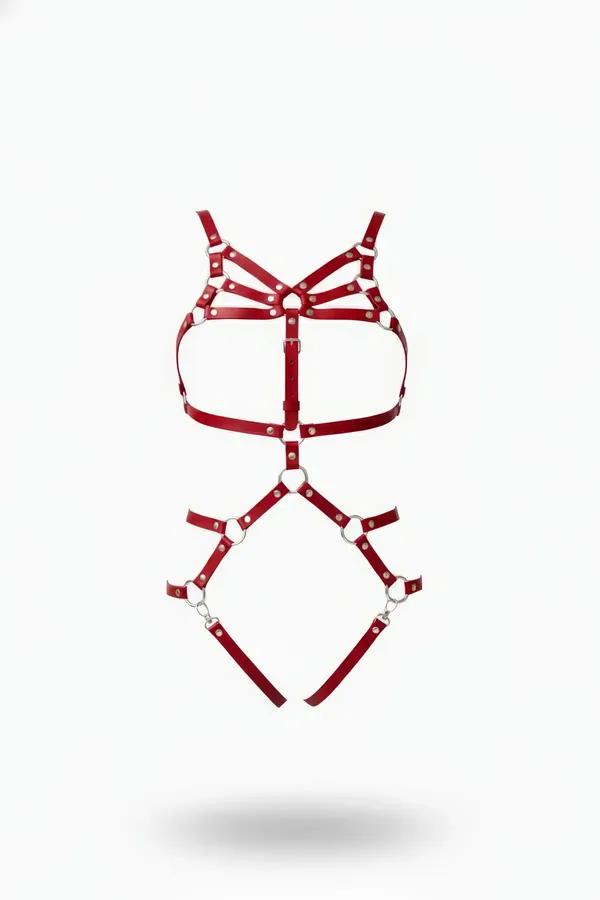 red faux leather full body harness with silver O-rings, triple chest cage straps, and garter leg frame on white background