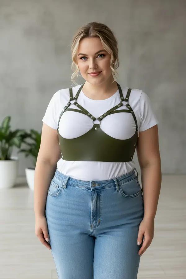dark olive caged underbust faux leather harness with silver rivet details and O-ring chest panel worn over cream tank top