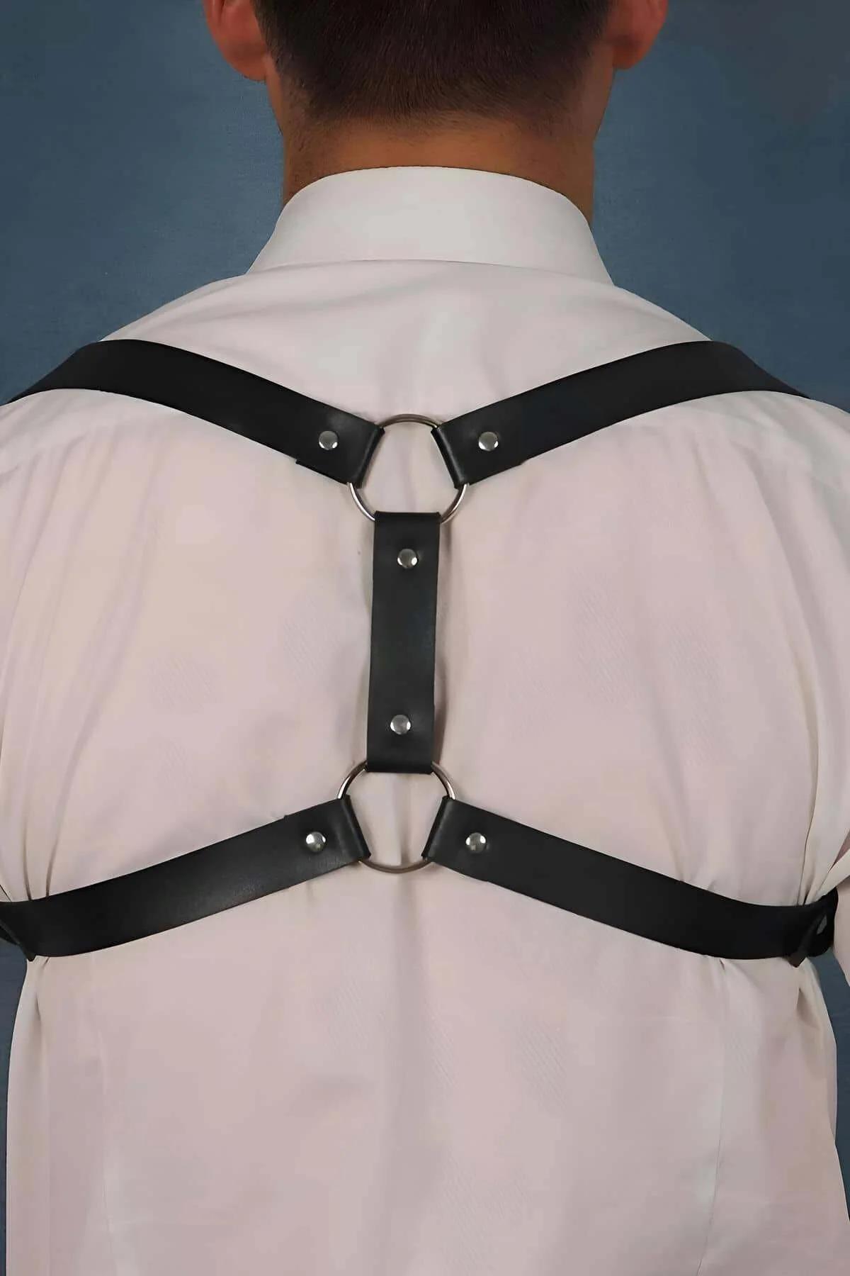 Men's Back Strap Harness Close-Up Silver O-Ring Detail Black Leather Straps with Dual Metal Rings on Model