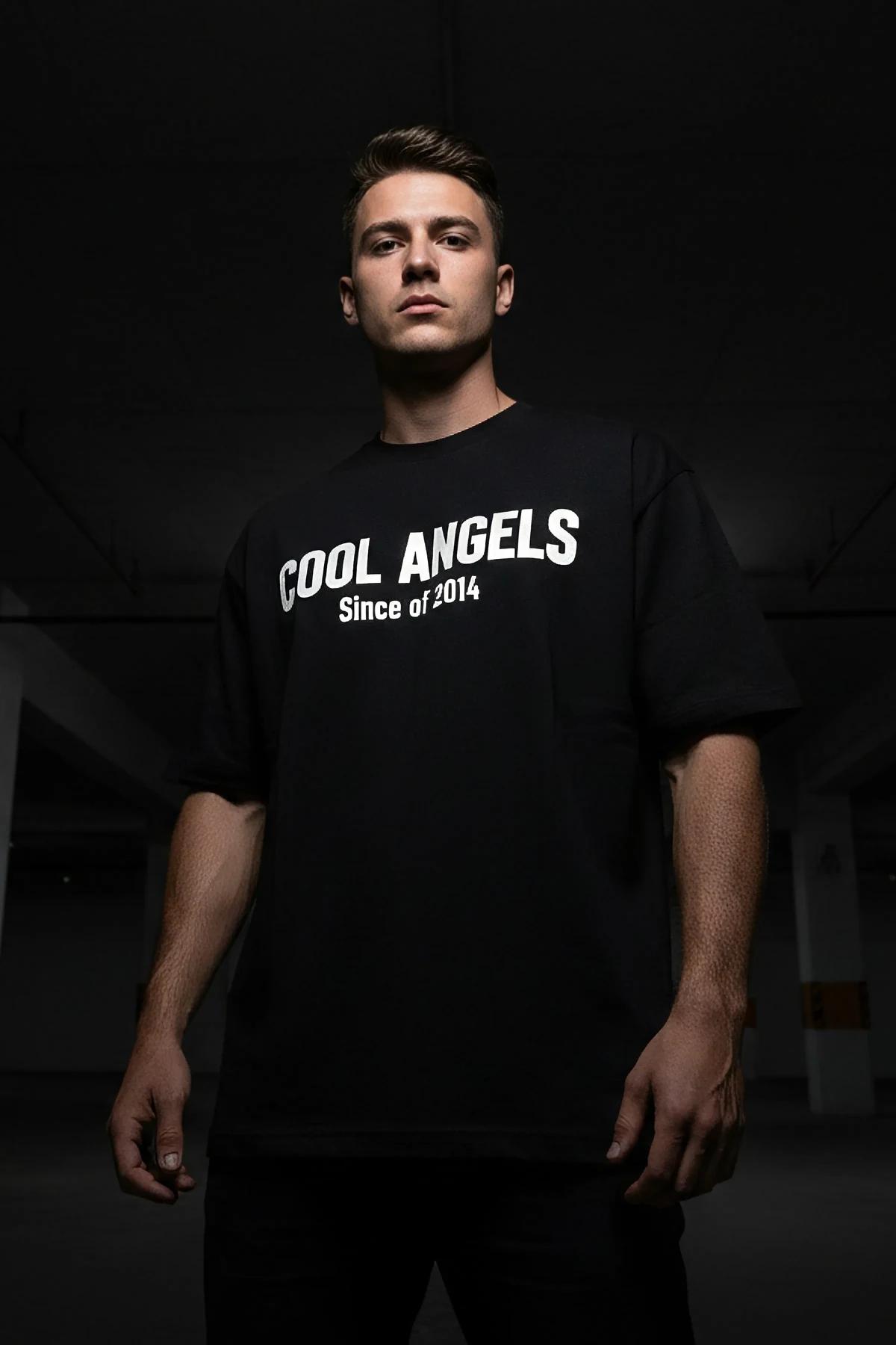 black oversized glow-in-the-dark reflective t-shirt with bold COOL ANGELS Since of 2014 chest graphic lit in low light