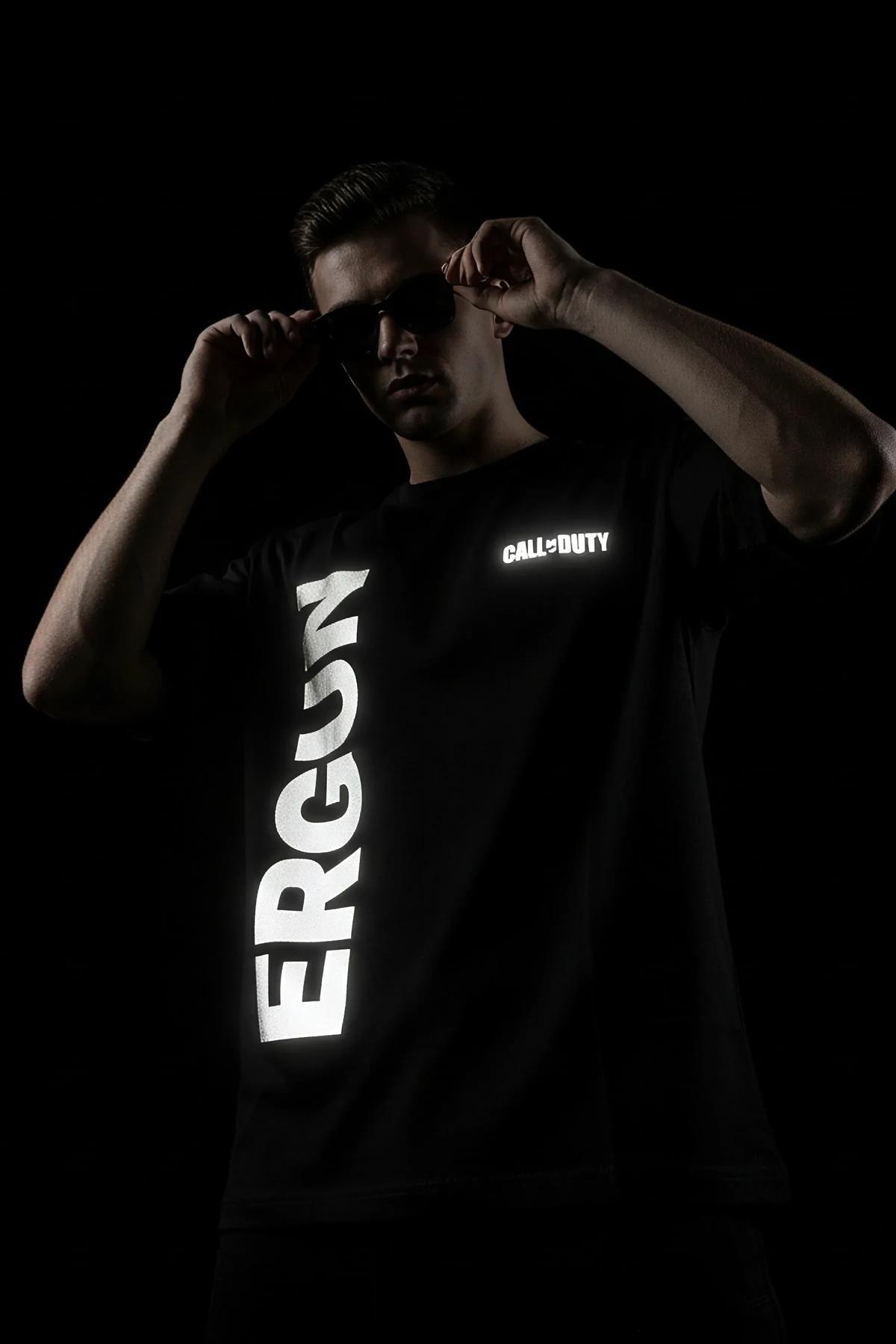 black reflective custom text t-shirt with bright white retroreflective print glowing under direct light on male model