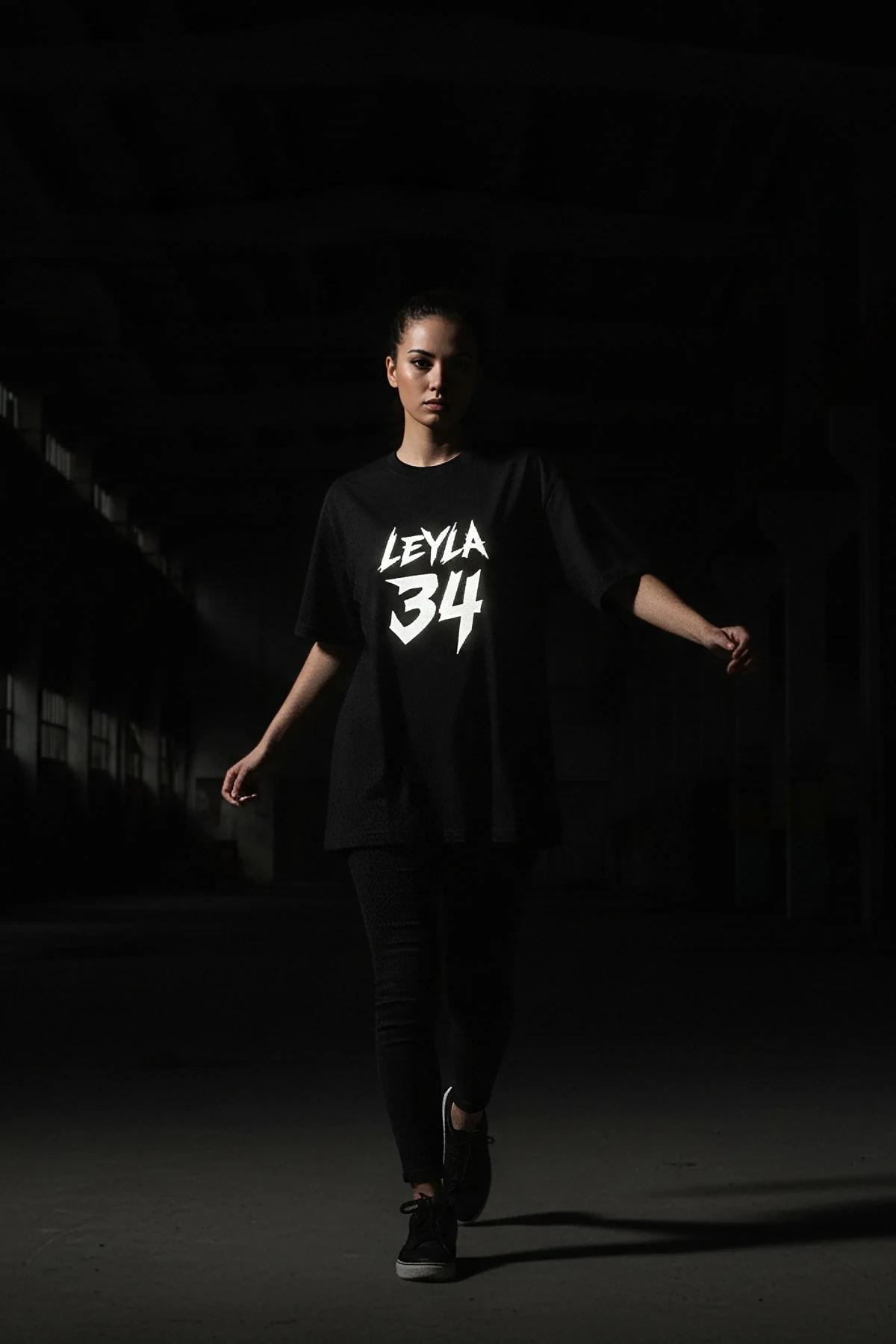 Oversized black cotton t-shirt with white graffiti-script graphic print, drop-shoulder cut and elongated hem