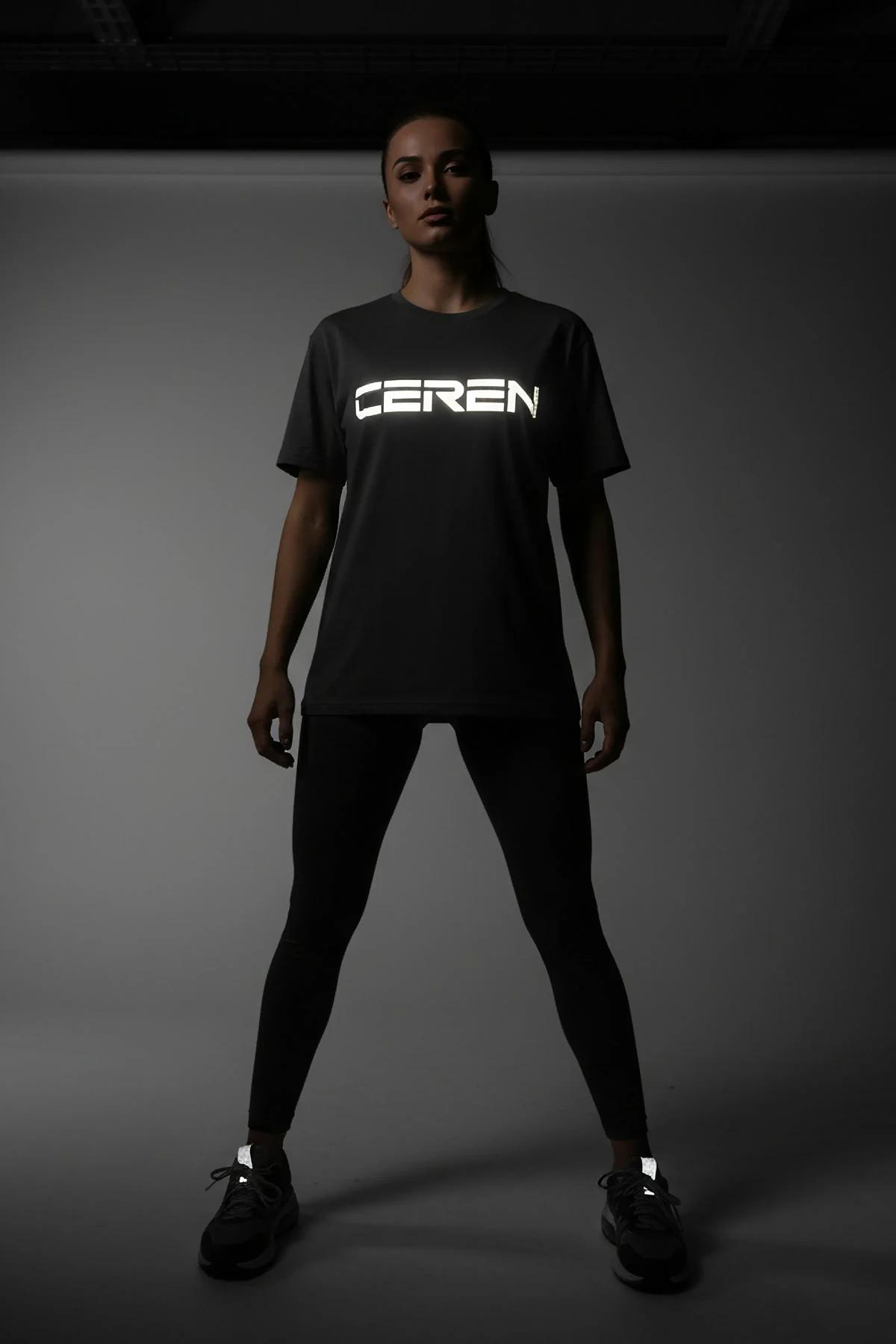 close-up of reflective screen-print Dance Club graphic on black jersey fabric under flash light