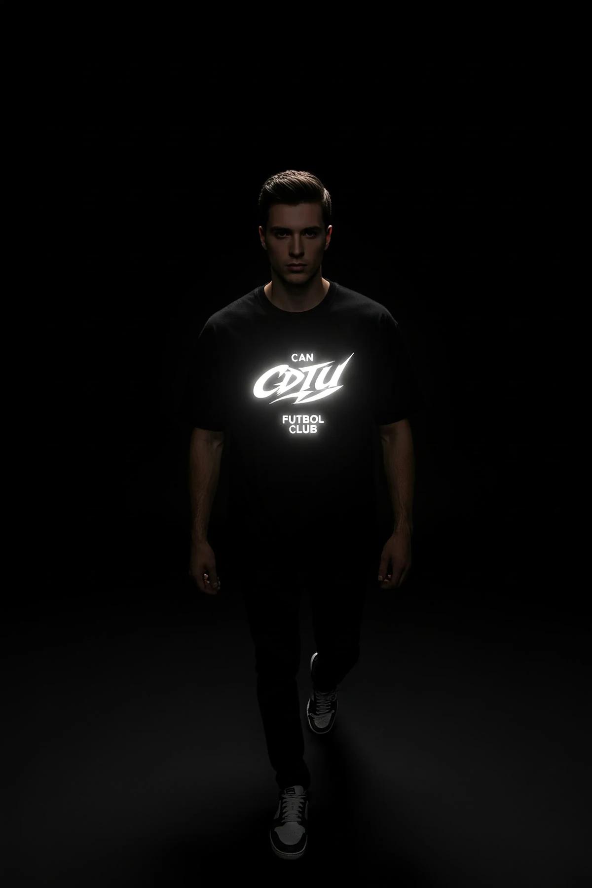 close-up of reflective logo print on black tee showing bright white glow effect in low light