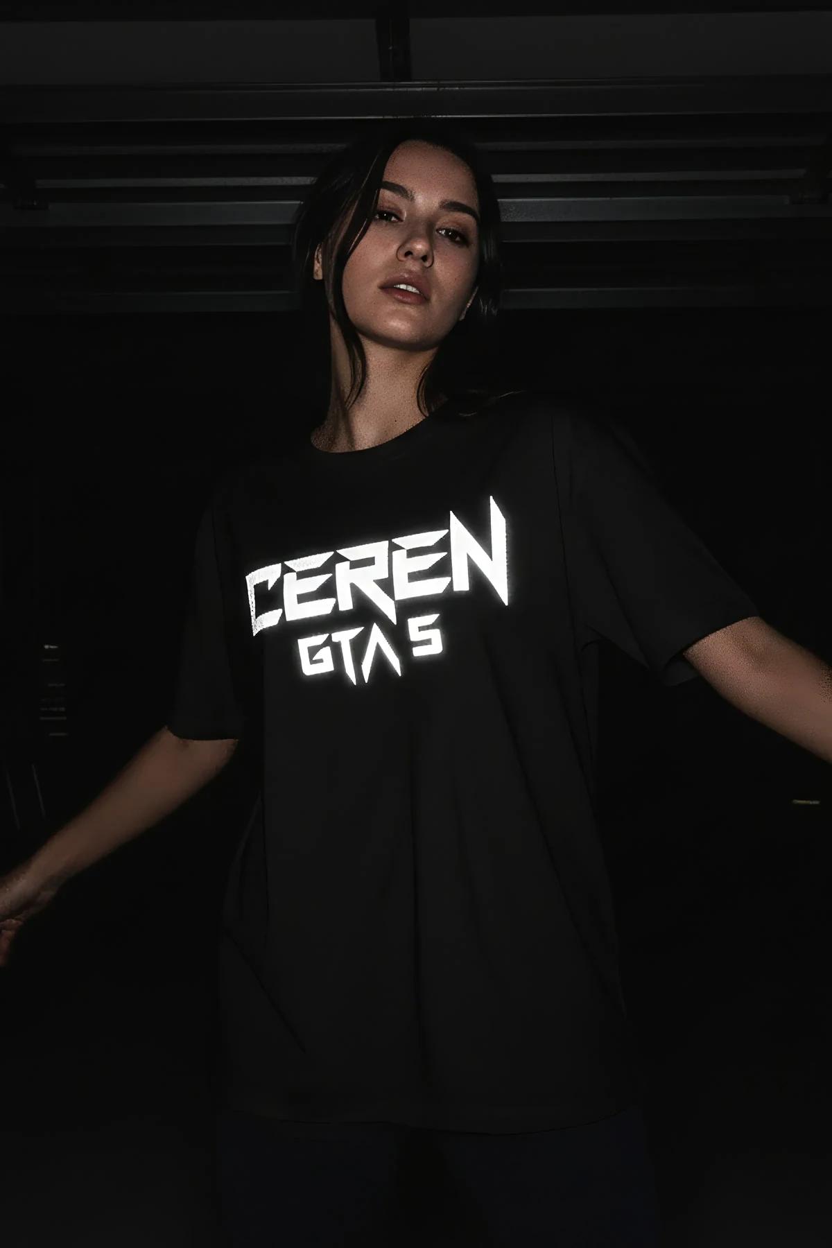 boxy dropped-shoulder black graphic t-shirt full length view against dark background