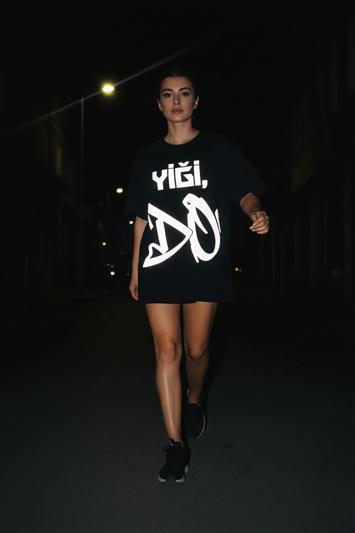 close-up of reflective white segmented typography on black cotton t-shirt chest panel