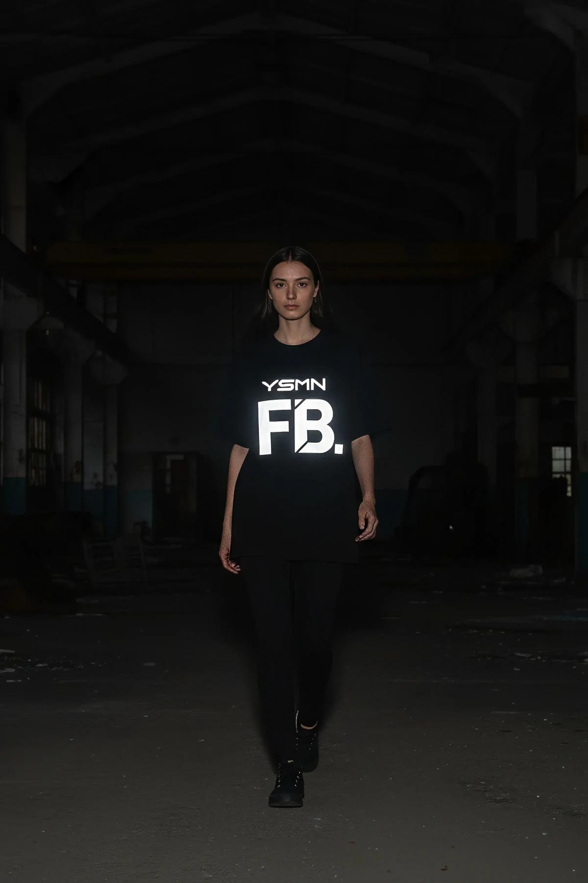 black reflective graphic t-shirt bold white YSMN logo glowing on chest in low light