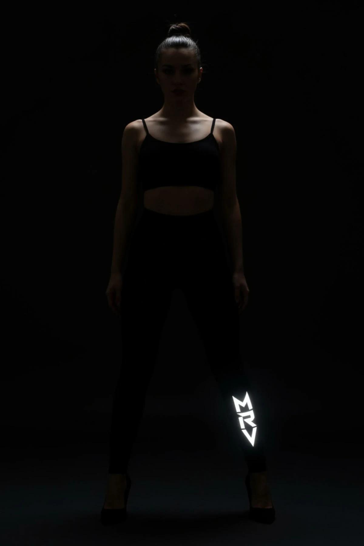 black glow-in-the-dark high-waist leggings with white reflective FT M brush-script logo on lower left leg