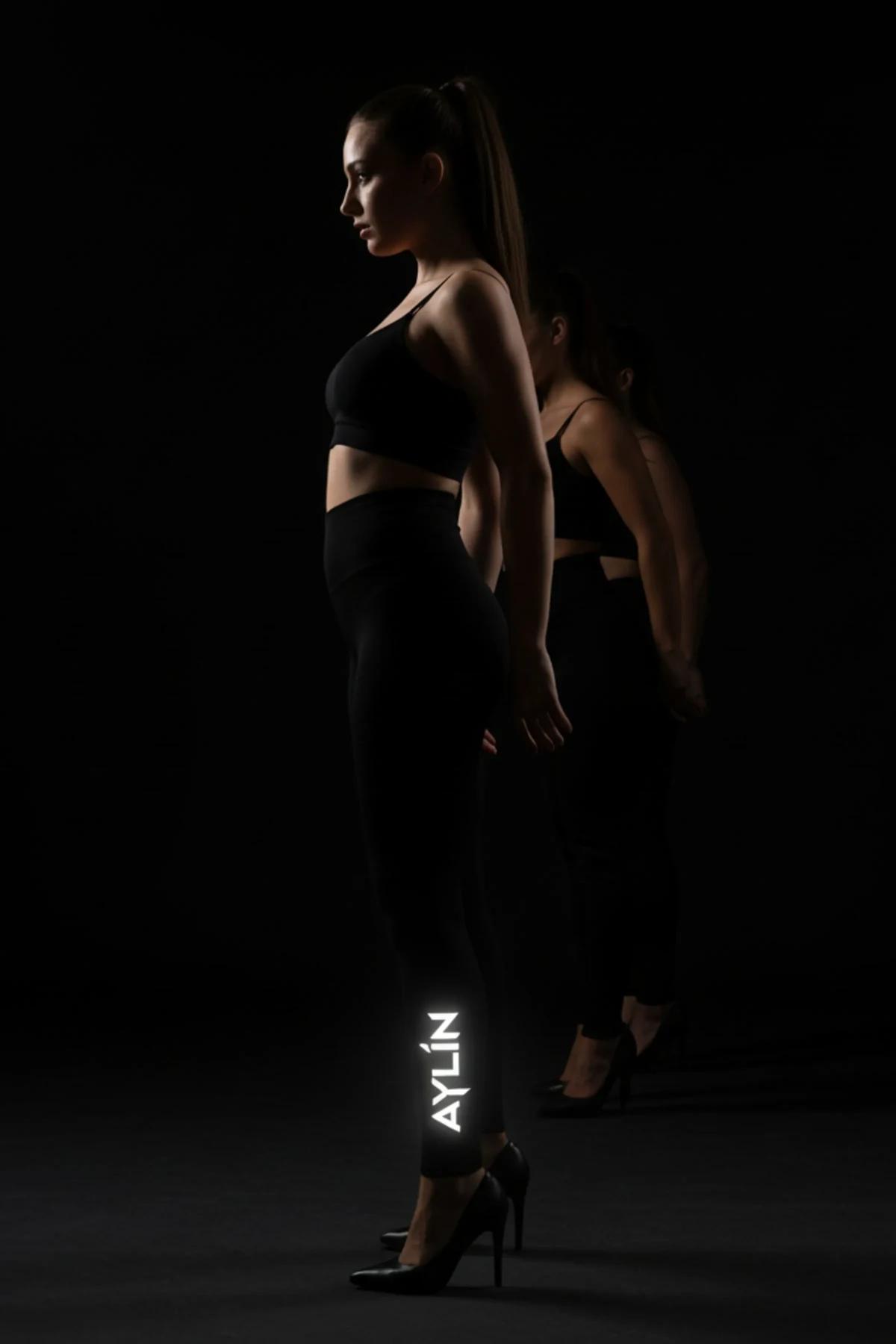 black glow-in-the-dark high-waist leggings with white reflective FT M brush-script logo on lower left leg