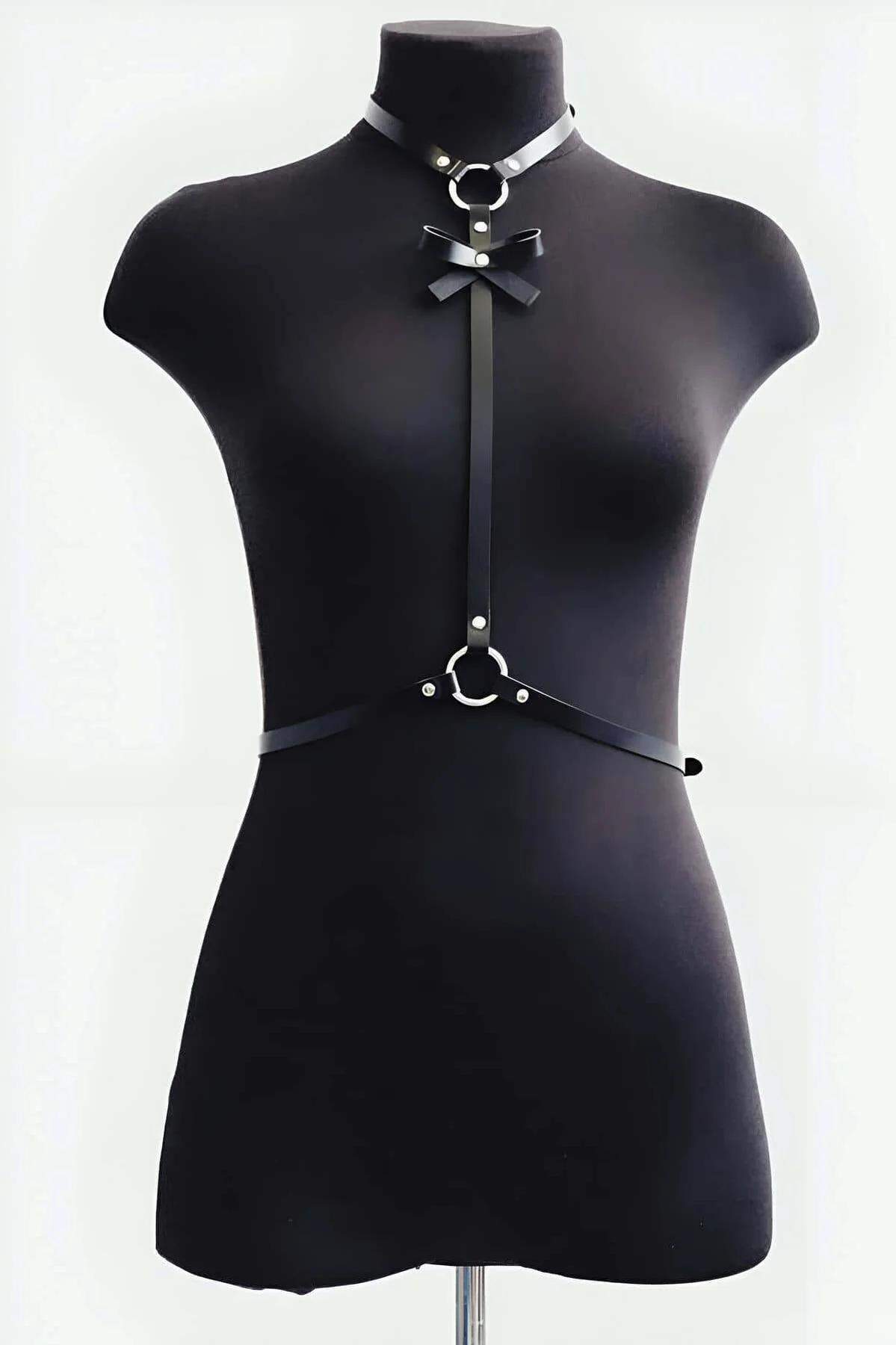 faux leather bow chest harness waist O-ring detail worn over black bodysuit