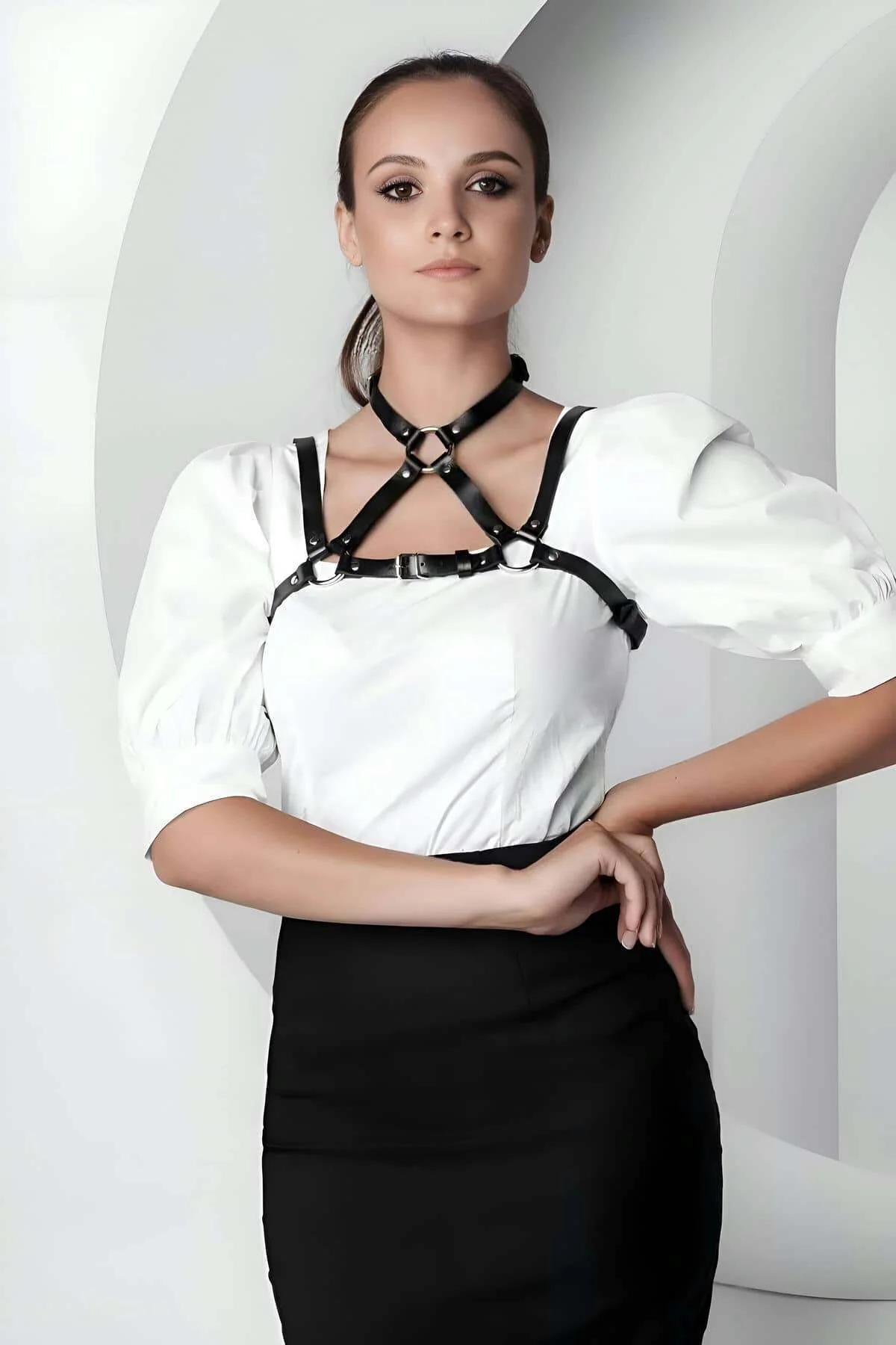 Siyah vegan deri crop yaka harness, gümüş O-halka ve toka, beyaz bluz üzerine giyilmiş kadın