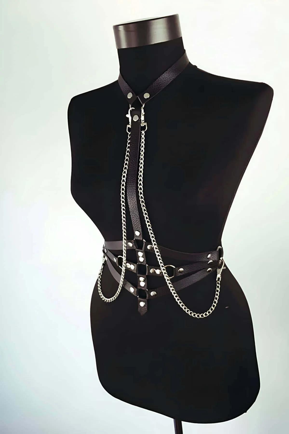 black faux leather body harness with silver chain draping chest to waist, silver O-rings and rivets, adjustable buckle waist 