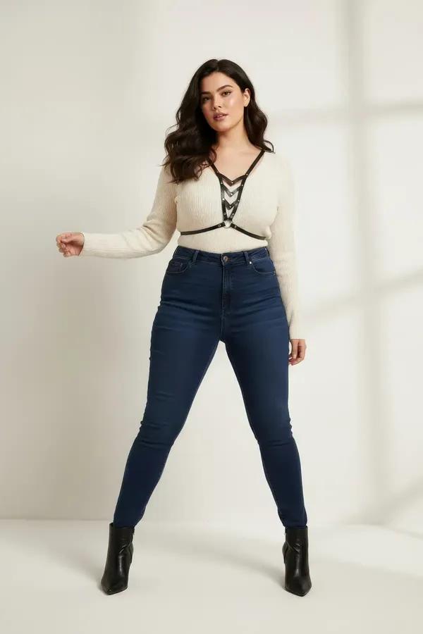 Black faux leather v-neck chest harness with cascading interlinked silver O-rings worn over cream knit top