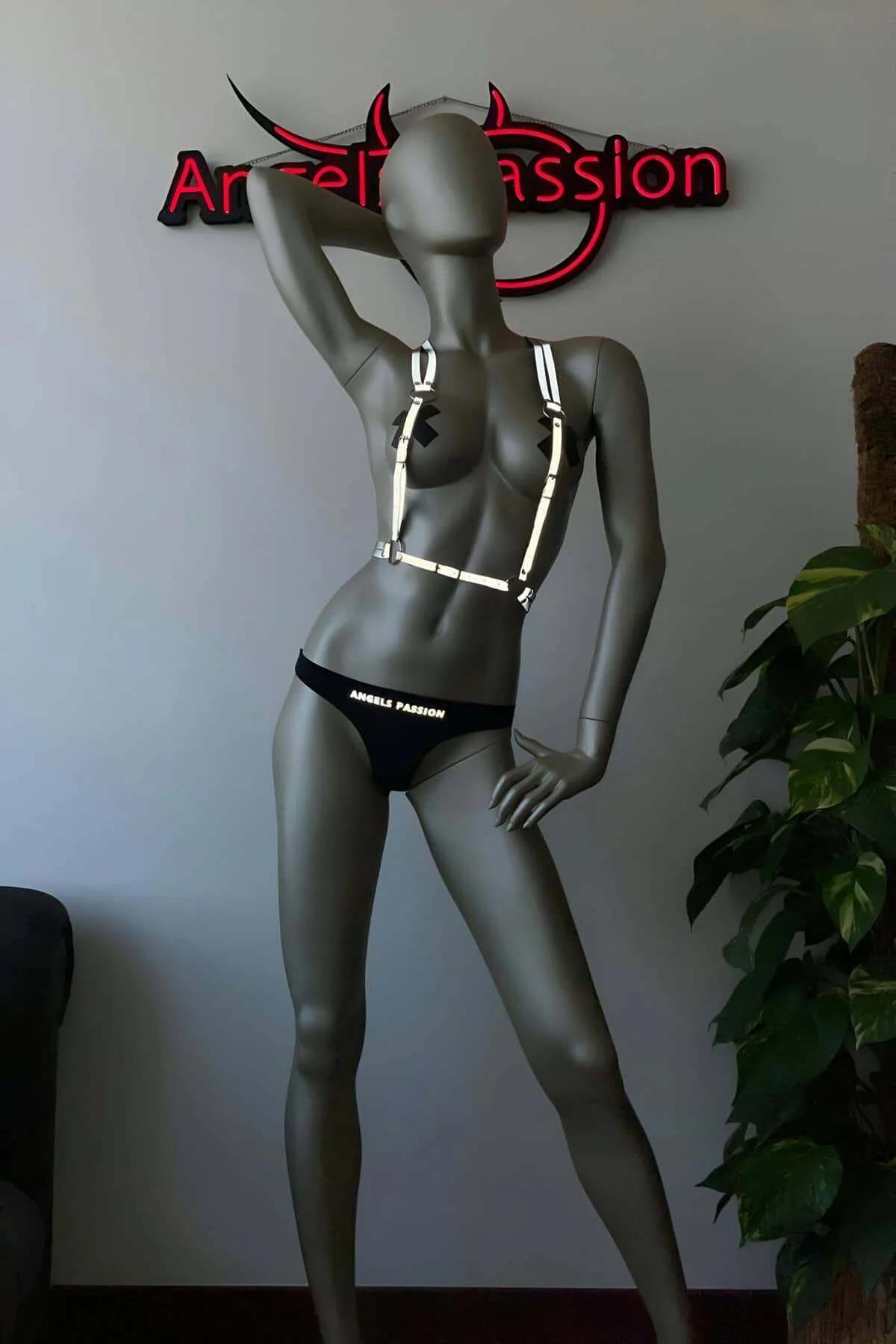 Flat-lay of adjustable reflective body harness showing slider buckles and full strap layout