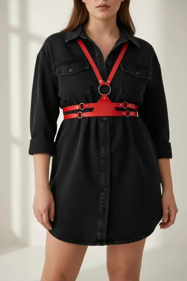 red faux leather chest harness with silver O-ring and buckles worn over black long-sleeve top, full front view