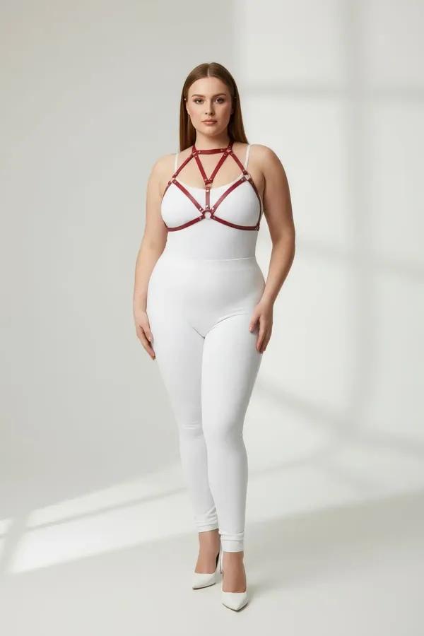 red faux leather strappy body harness with gold O-ring connectors worn as chest harness over white bodysuit