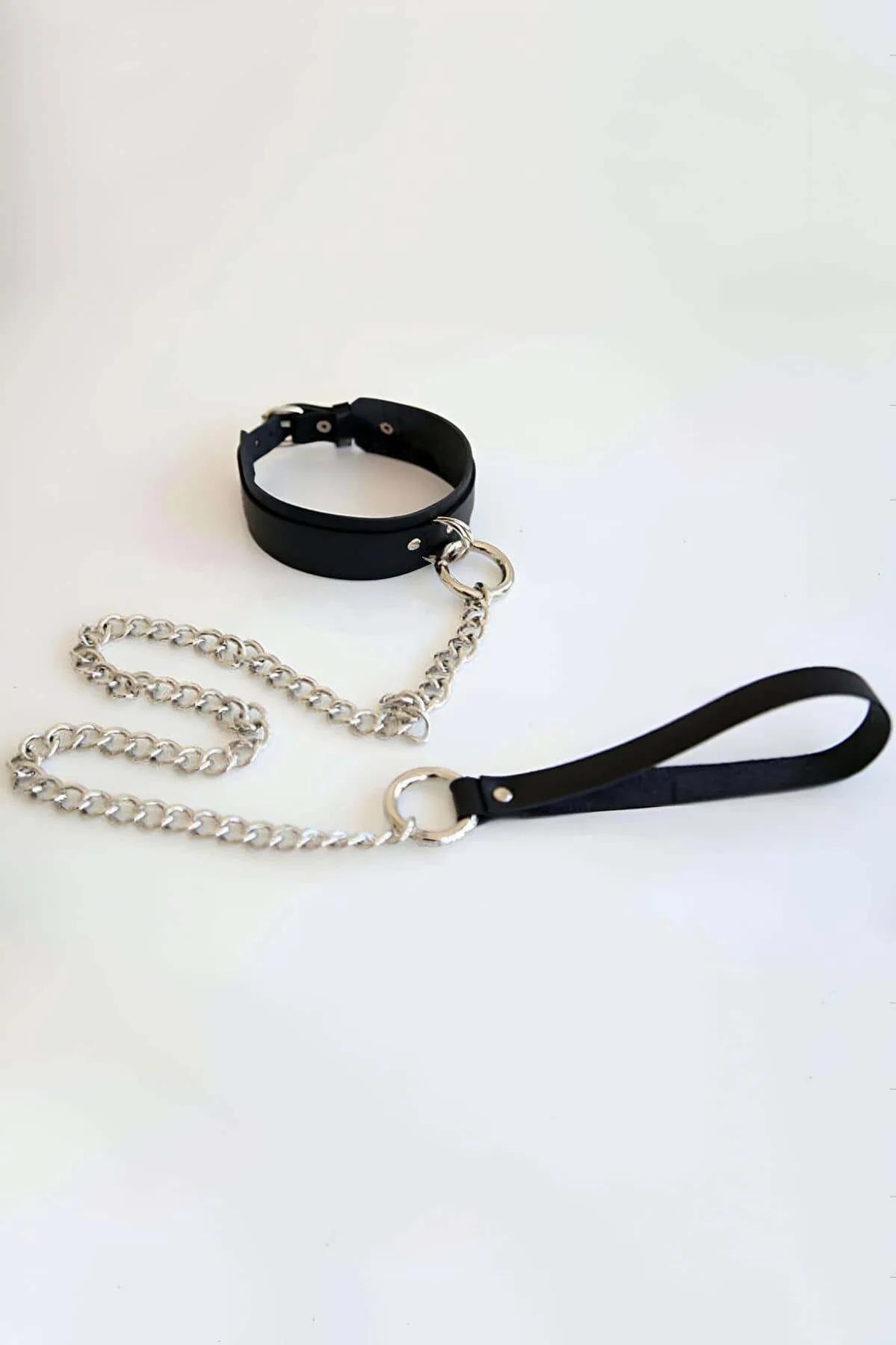 Close-up of silver O-ring and link chain clipped to black vegan leather choker band