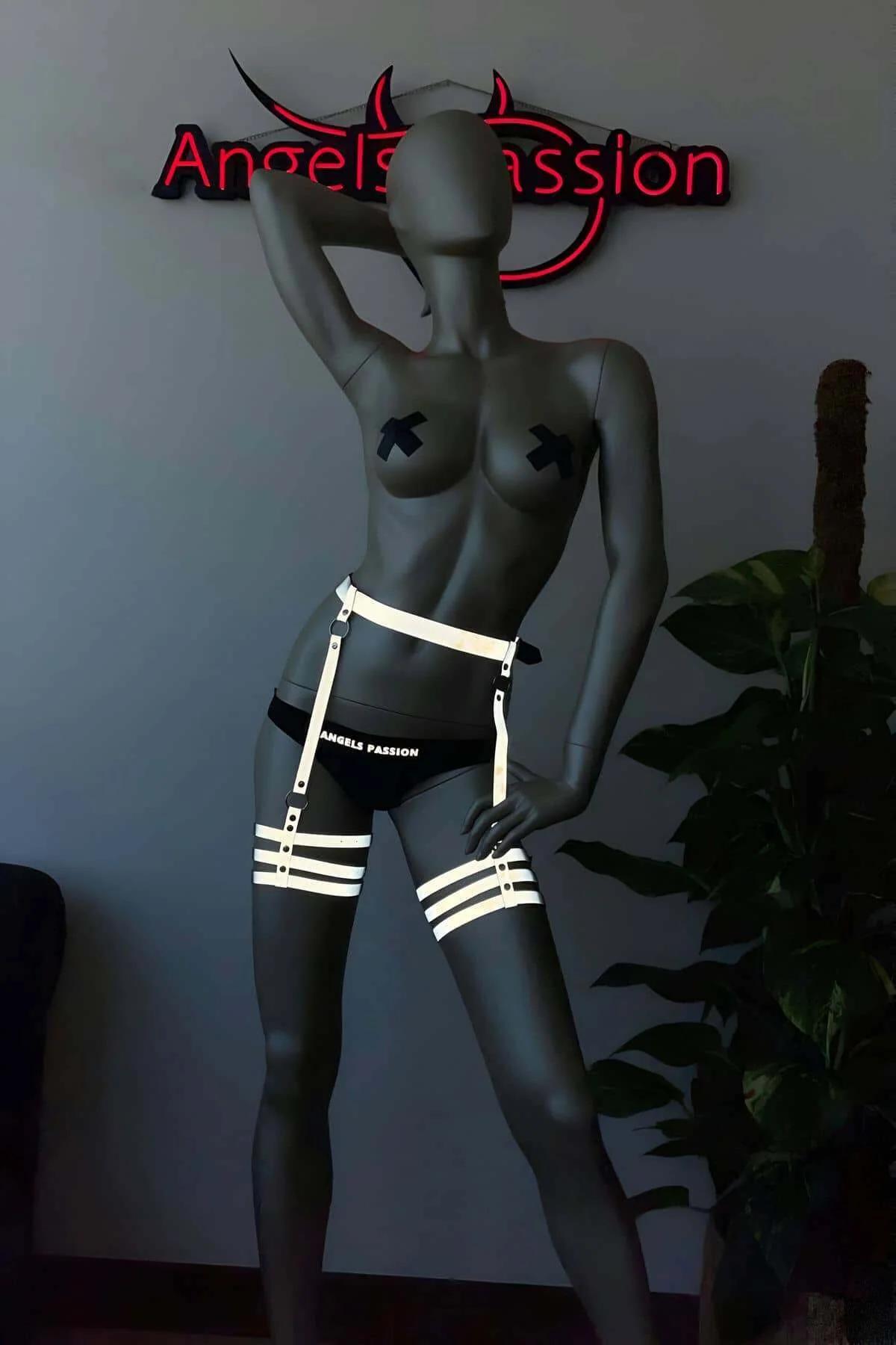 Close-up of reflective tape on black elastic thigh straps with silver O-ring connectors
