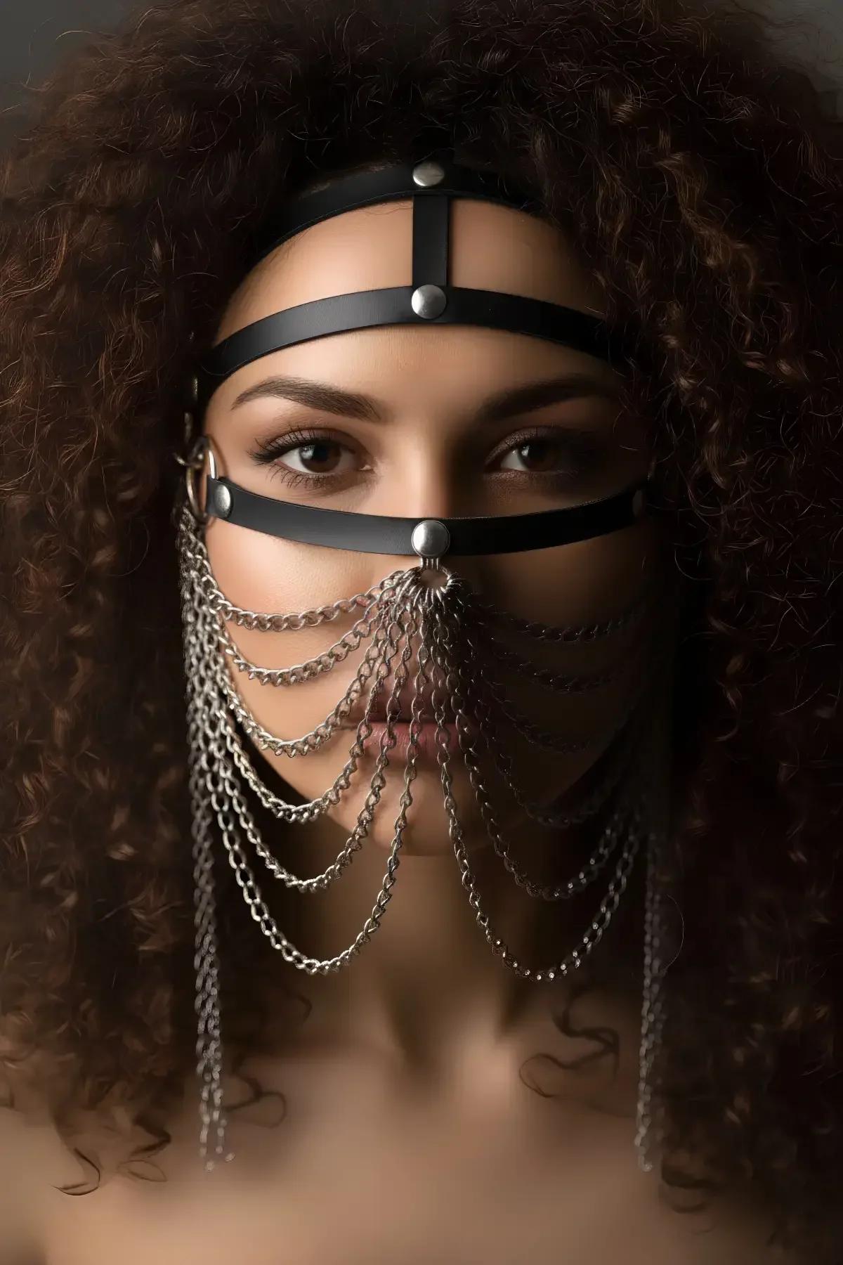 Side view of silver-tone chains cascading from O-ring on black leather face harness