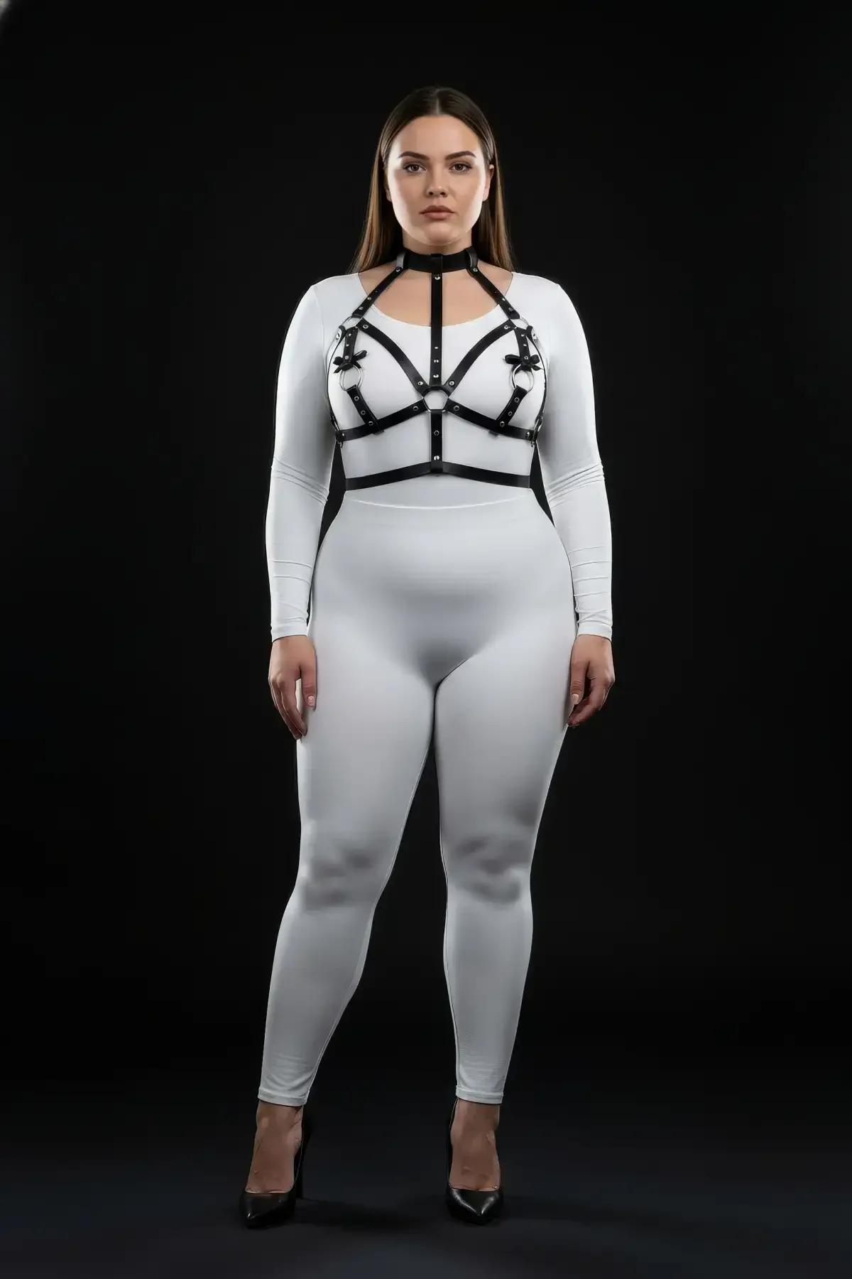 plus size model wearing black faux leather chest harness with choker over white long-sleeve bodysuit