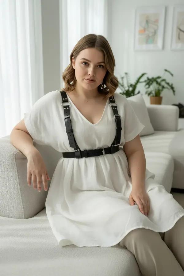 Black faux leather multi-buckle chest and waist harness vest with silver rectangular buckles worn over cream shirt