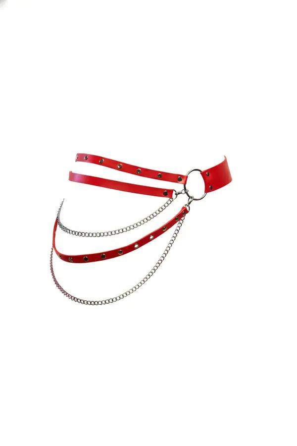 red faux leather waist harness with three draping silver chains and front O-ring, studded eyelet straps on white background