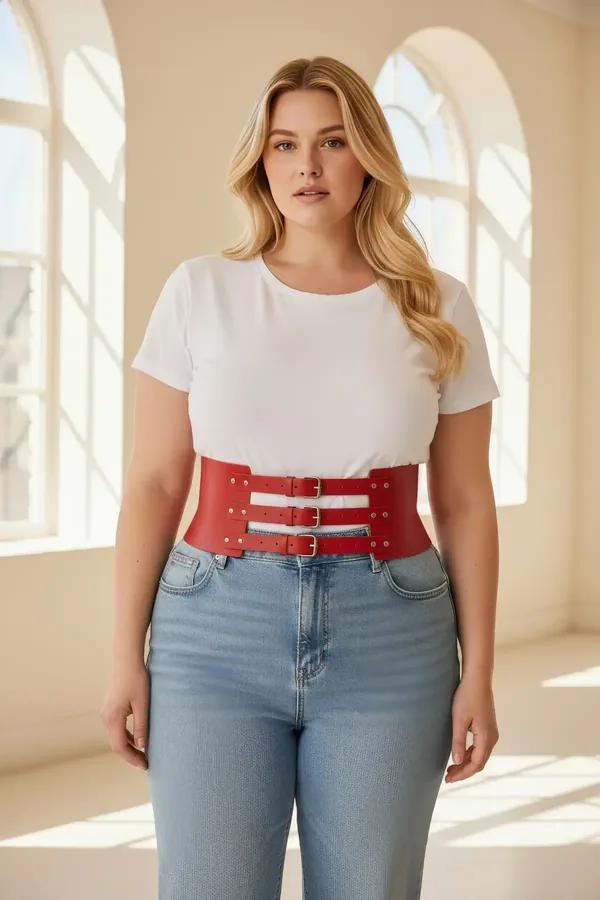 red faux leather wide waist harness with three gold-tone buckles worn over cream tank and wide-leg trousers