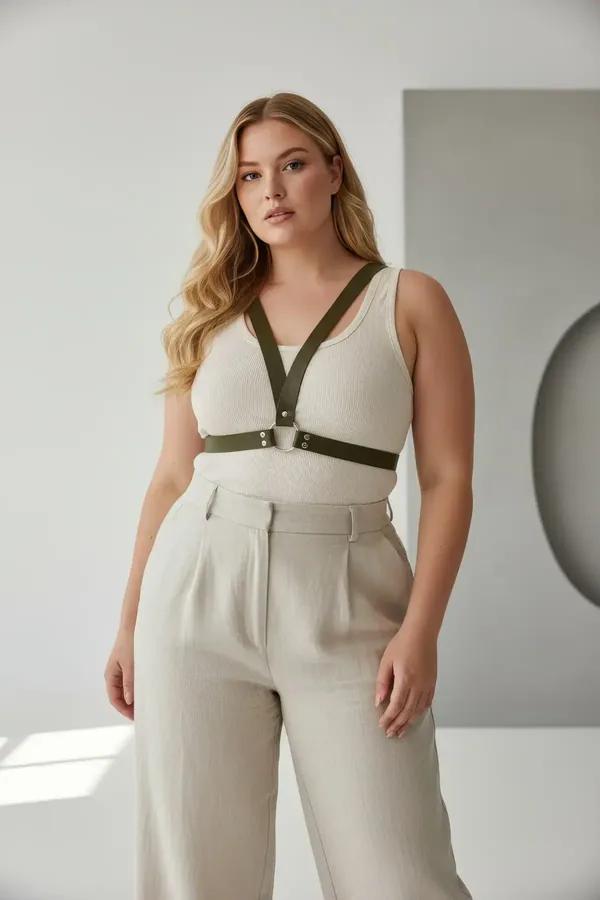 olive green faux leather o-ring chest harness with gold-tone hardware worn over white tank top plus size model