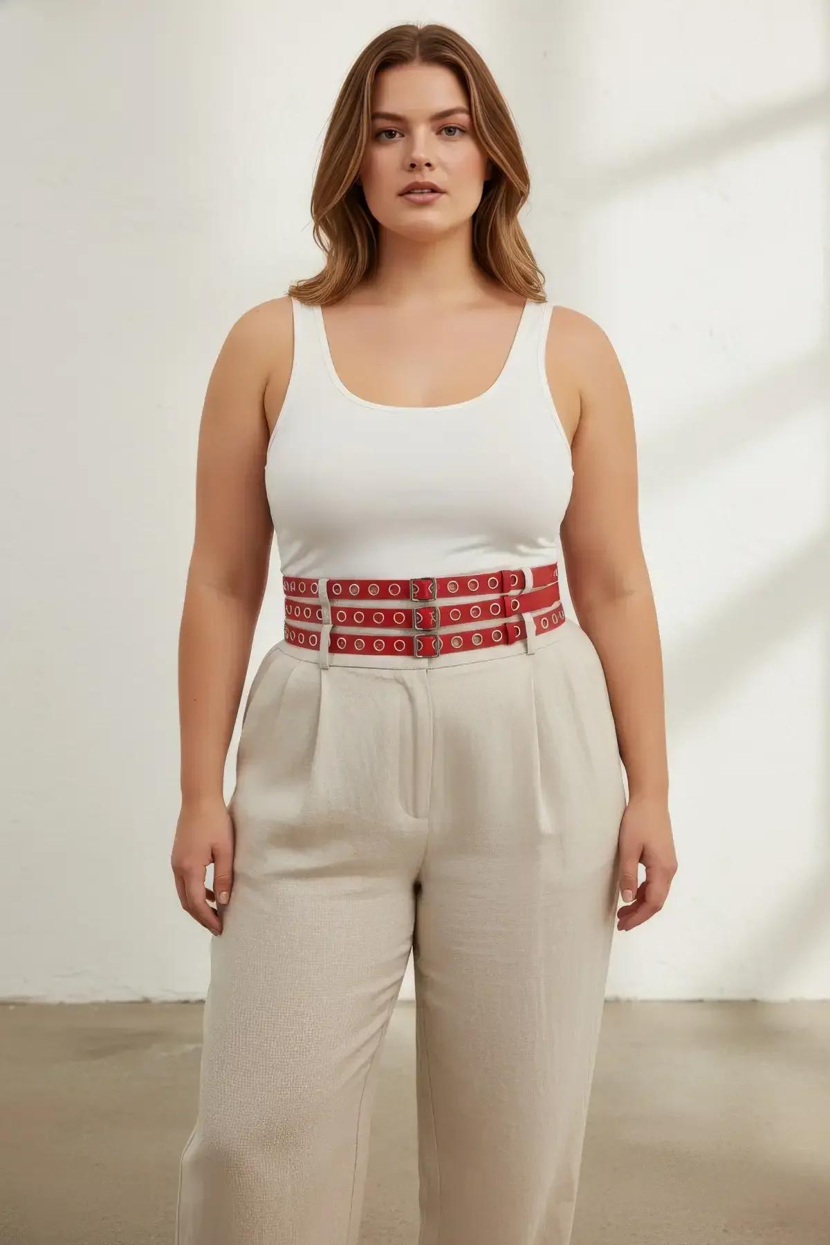 close-up of red faux leather triple band harness belt with silver-tone circular eyelet detail