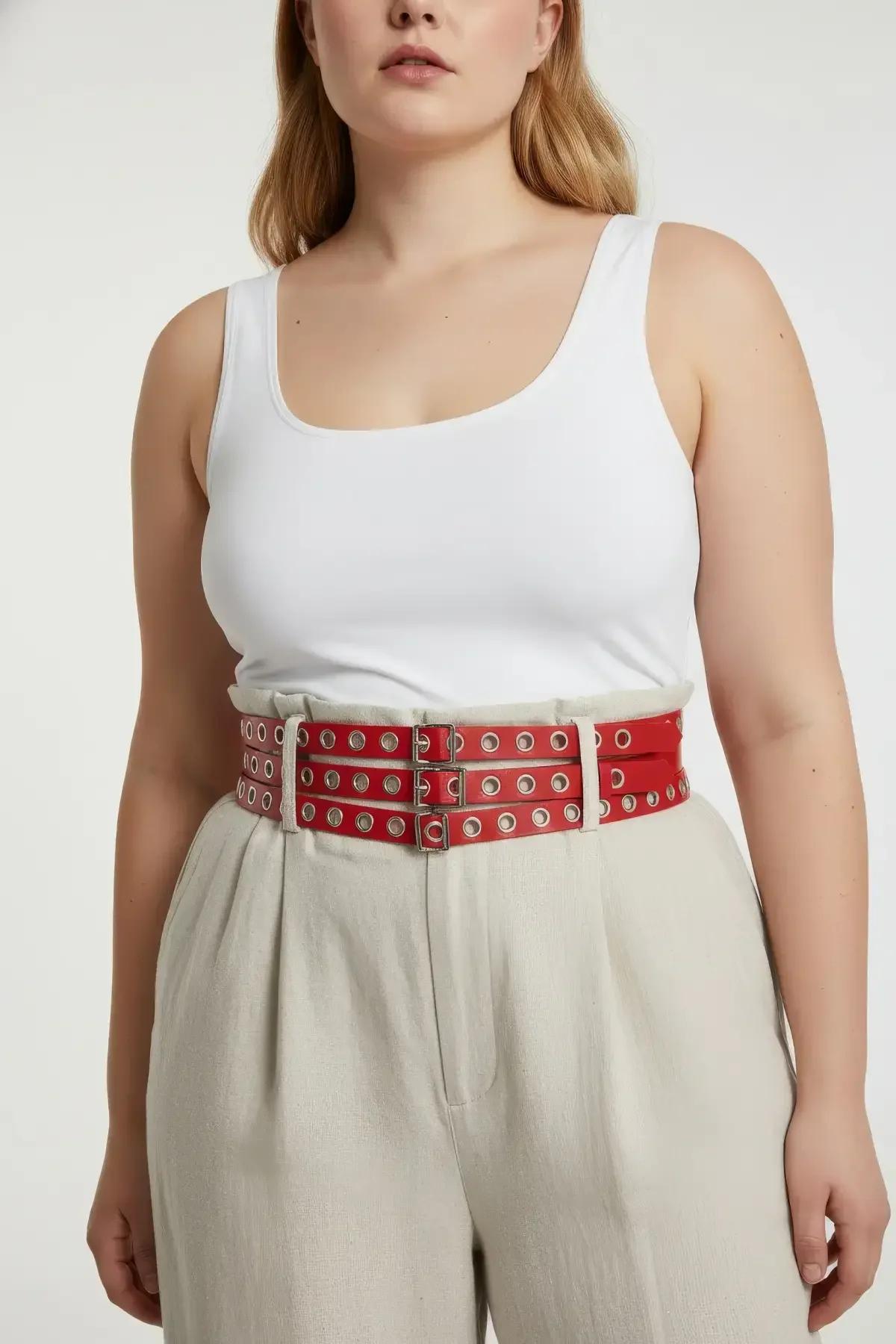 red triple-row harness belt styled over white dress showing corset-like waist definition