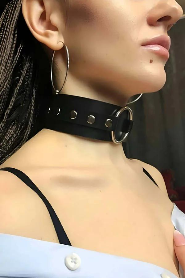 Siyah geniş vegan deri choker gümüş O-halka ve perçin detaylı boyun aksesuarı, kadın boynu üzerinde