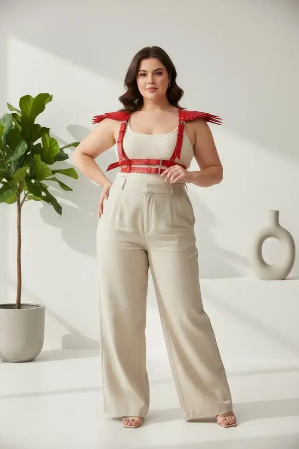 red faux leather chest harness with fringe spike shoulder epaulettes and dual silver buckle straps worn over cream top