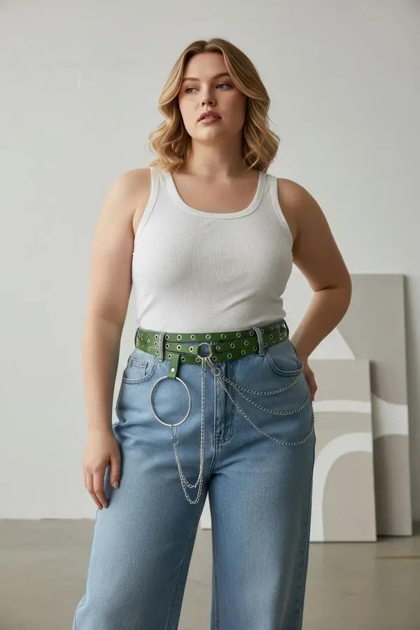Wide green vegan leather grommet belt with silver O-ring chain drape worn at natural waist over cream wide-leg trousers
