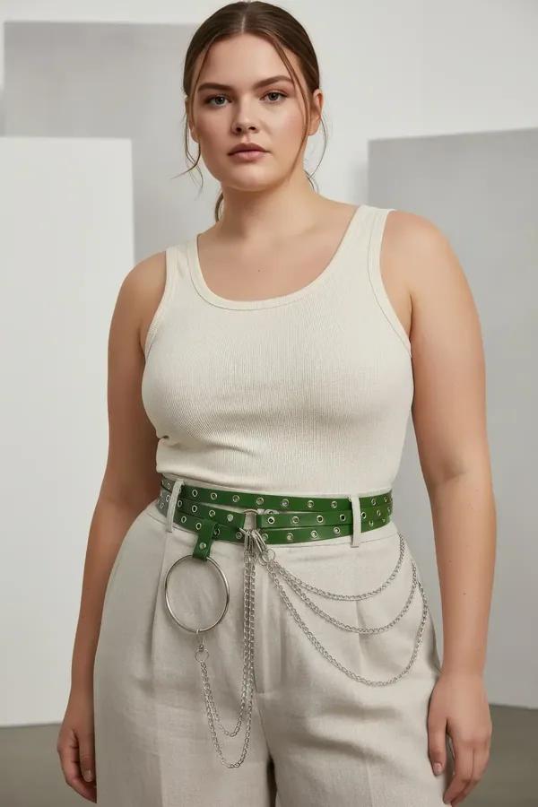 Wide green vegan leather grommet belt with silver O-ring chain drape worn at natural waist over cream wide-leg trousers