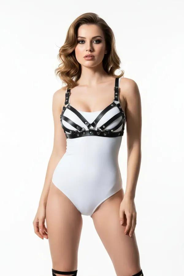 strappy black faux leather chest harness with five horizontal bands and gold-tone stud rivets worn over white bodysuit