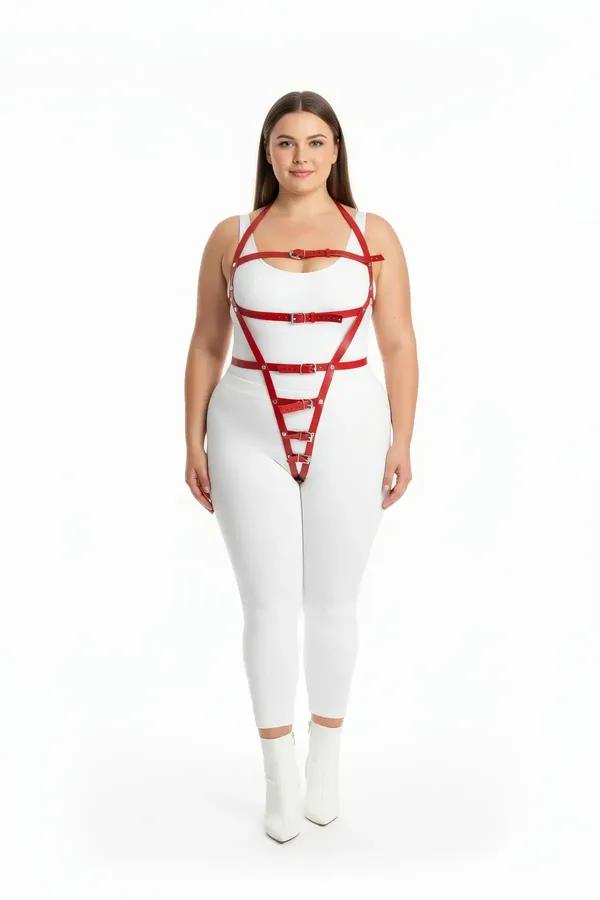 red faux leather body harness with geometric cage straps and silver buckles worn over white bodysuit plus-size model