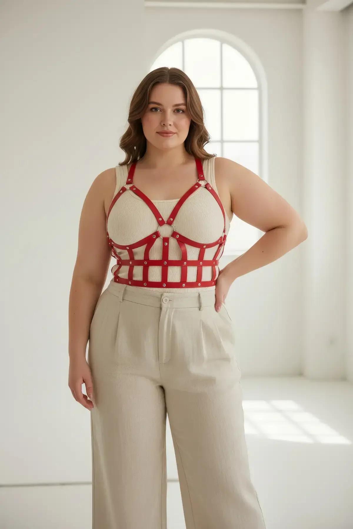 close-up of red caged bustier harness O-ring center connector and silver-tone zinc-alloy rivet studs at strap intersections