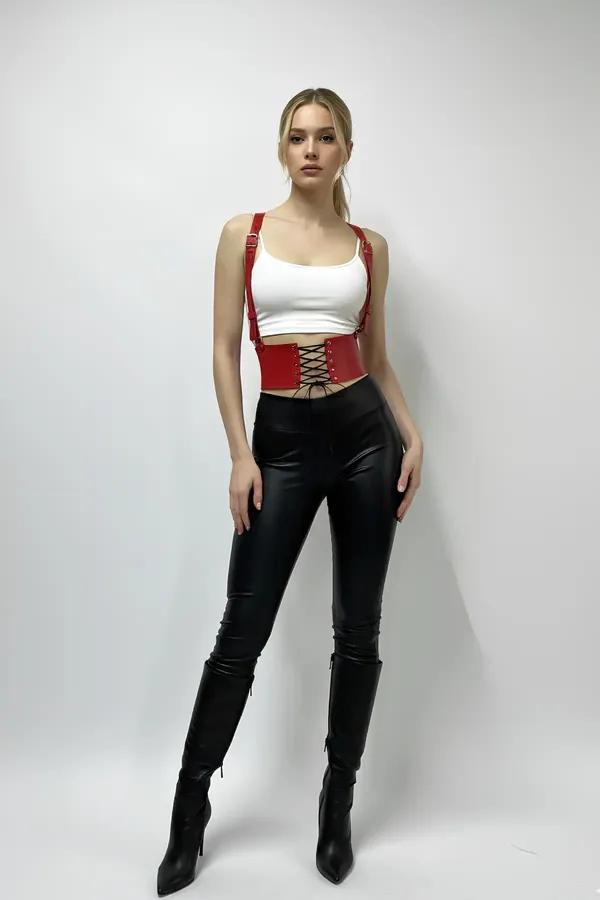 red faux leather waist harness with corset lace-up front and silver buckle shoulder straps worn over white crop top