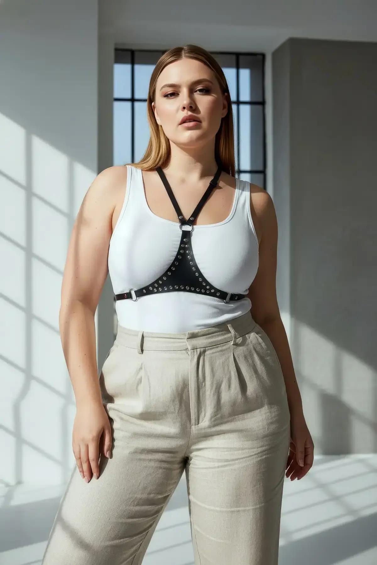 black faux leather chest harness with silver stud band and central O-ring worn over white tank top
