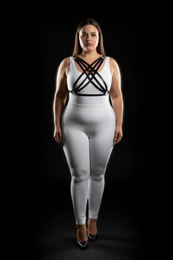 black faux leather chest harness with four crisscross diagonal straps and silver-tone studs worn over white outfit