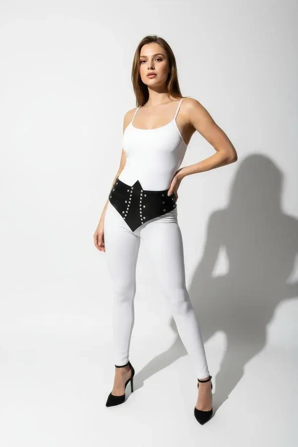 black faux leather studded waist cincher with silver eyelets and lace-up side panels worn over white bodysuit