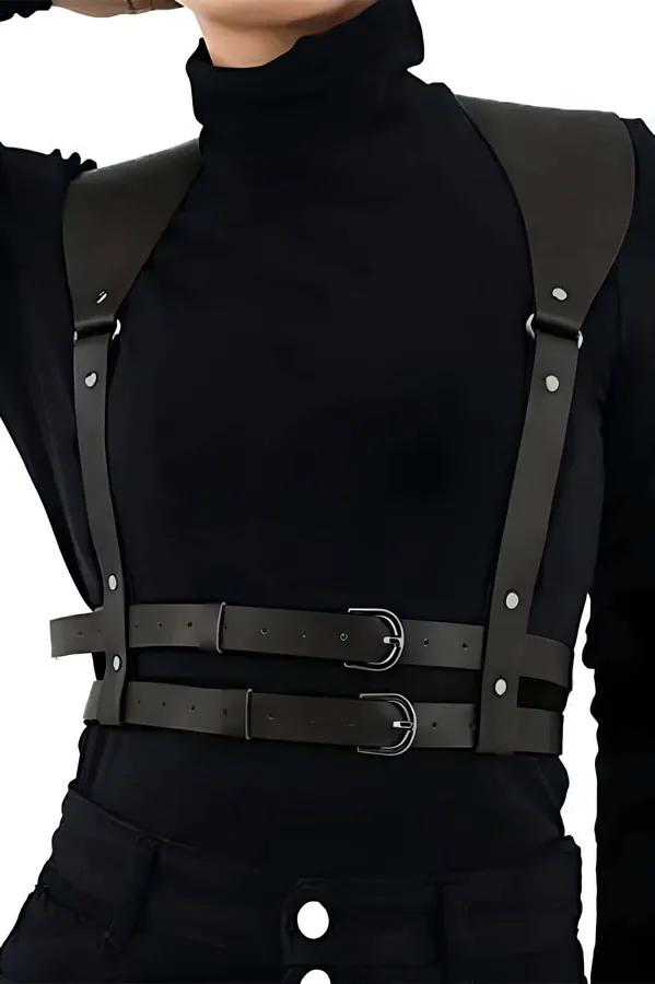 black faux leather chest harness with double silver buckles and wide structured shoulder panels worn over black turtleneck
