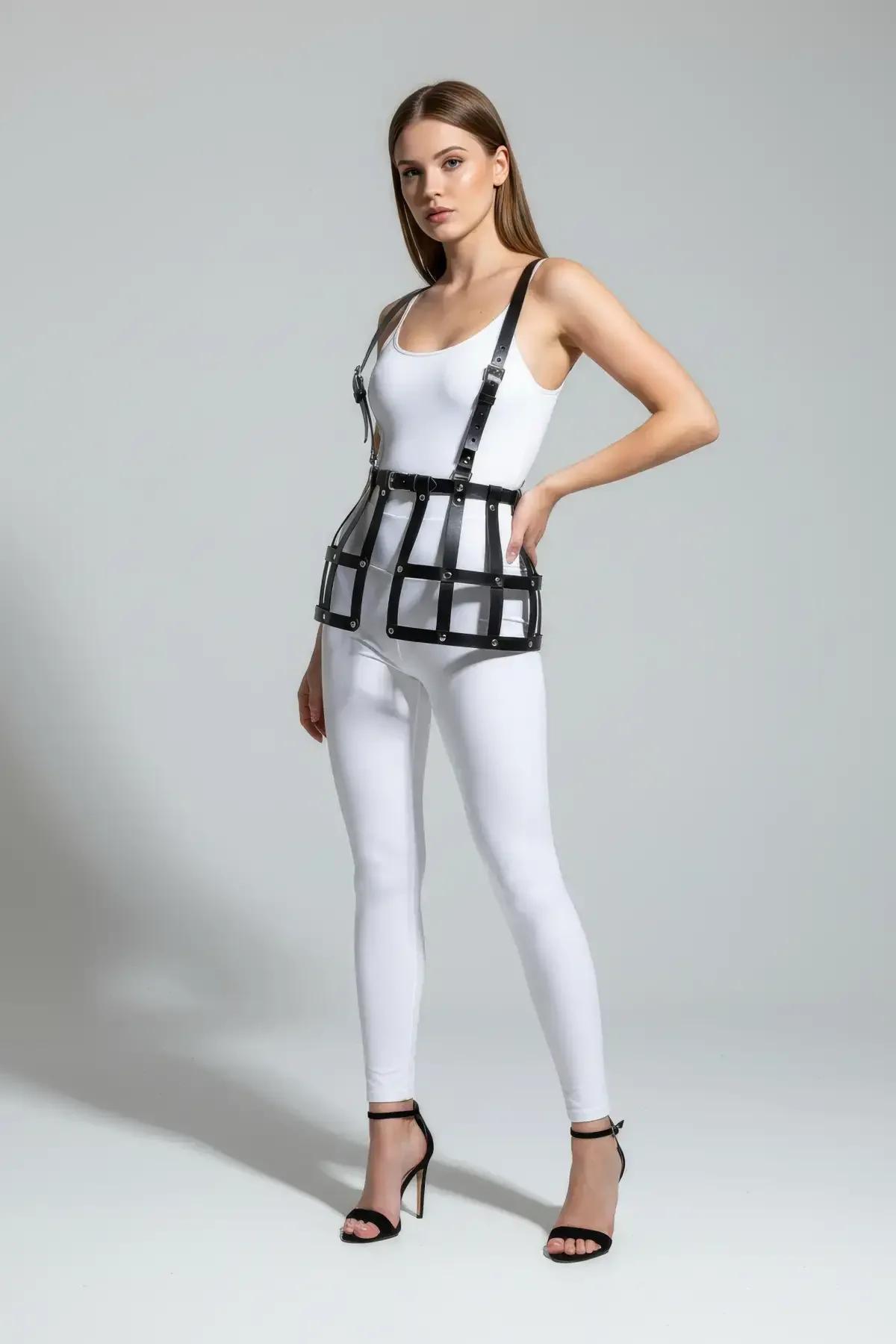 Side angle of black cage skirt harness over white leggings showing structured horizontal bar silhouette