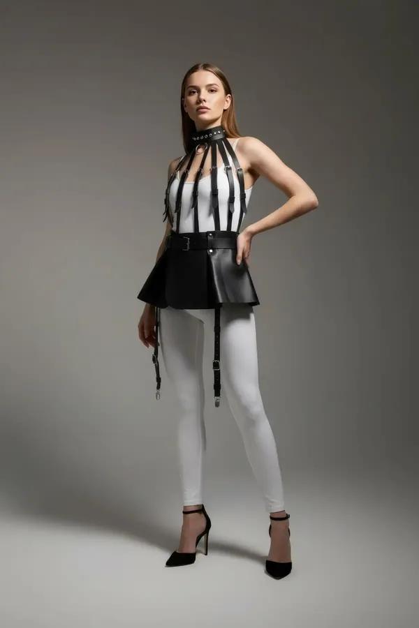 Black faux leather flared harness skirt with four adjustable silver-clip garter straps worn over white leggings