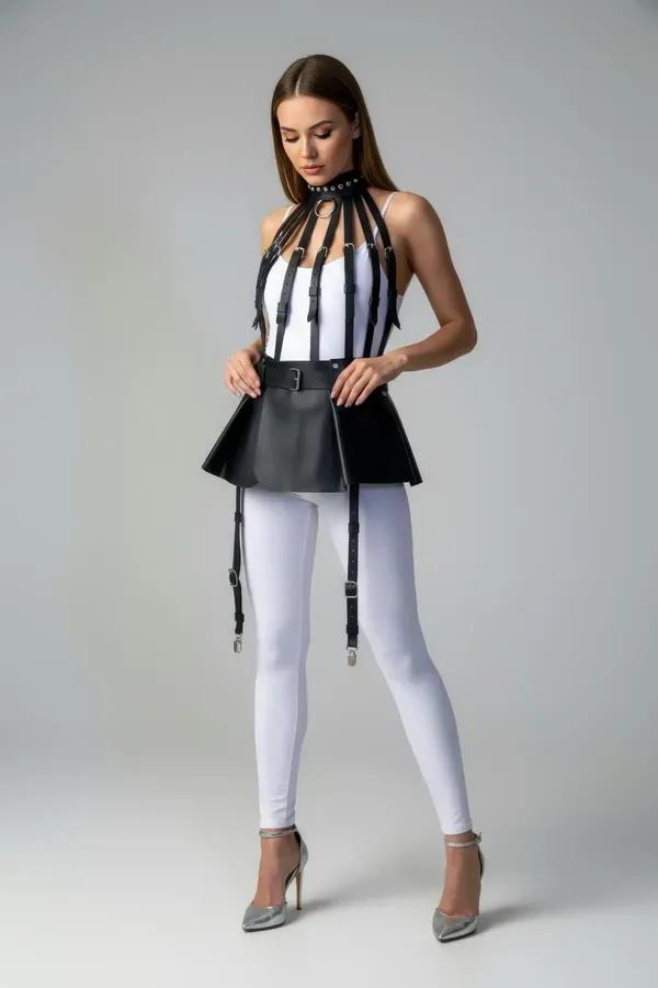 Black faux leather flared harness skirt with four adjustable silver-clip garter straps worn over white leggings
