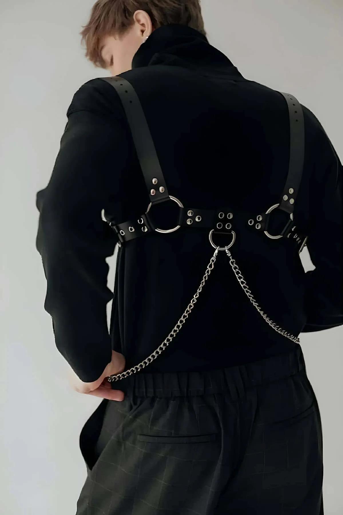 close-up of silver rivet clusters and central O-ring on black PU leather chest strap