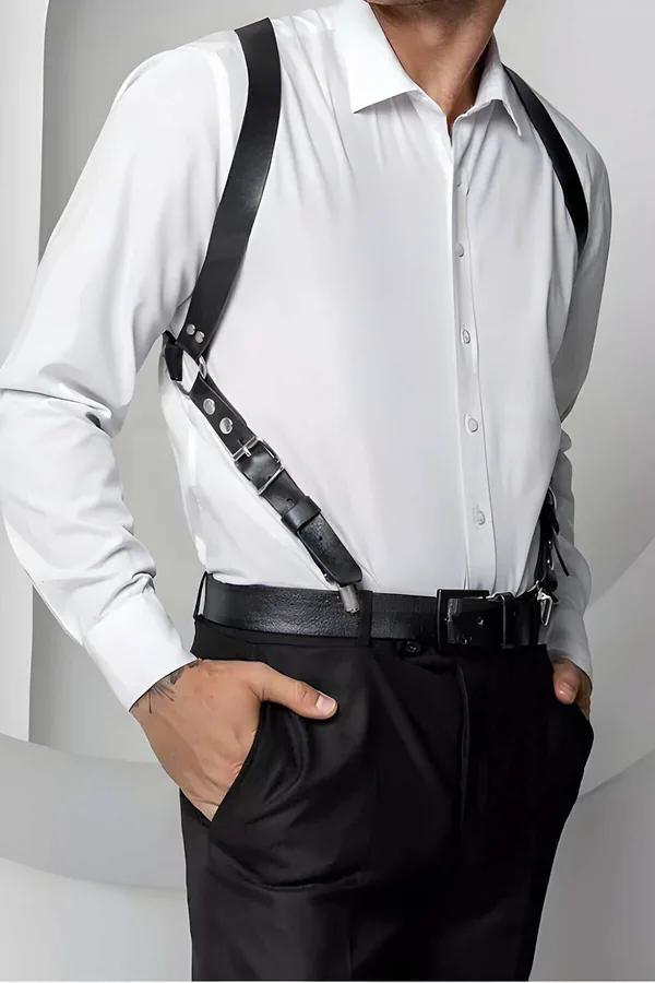 black faux leather single diagonal shoulder harness with silver buckle worn over white dress shirt