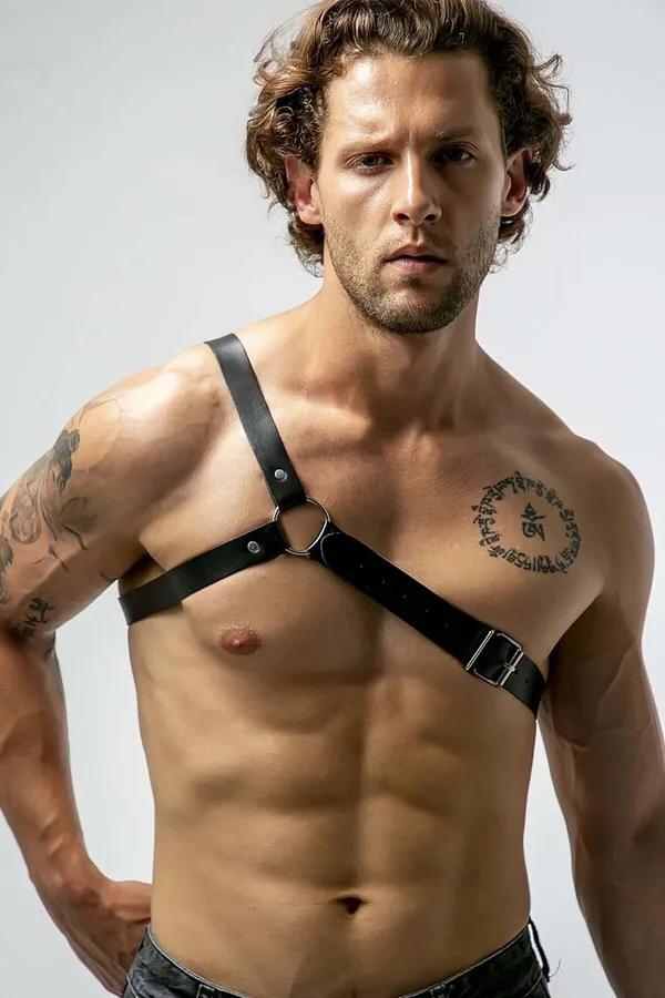 black faux leather asymmetrical chest harness single shoulder strap silver O-ring buckle on male model